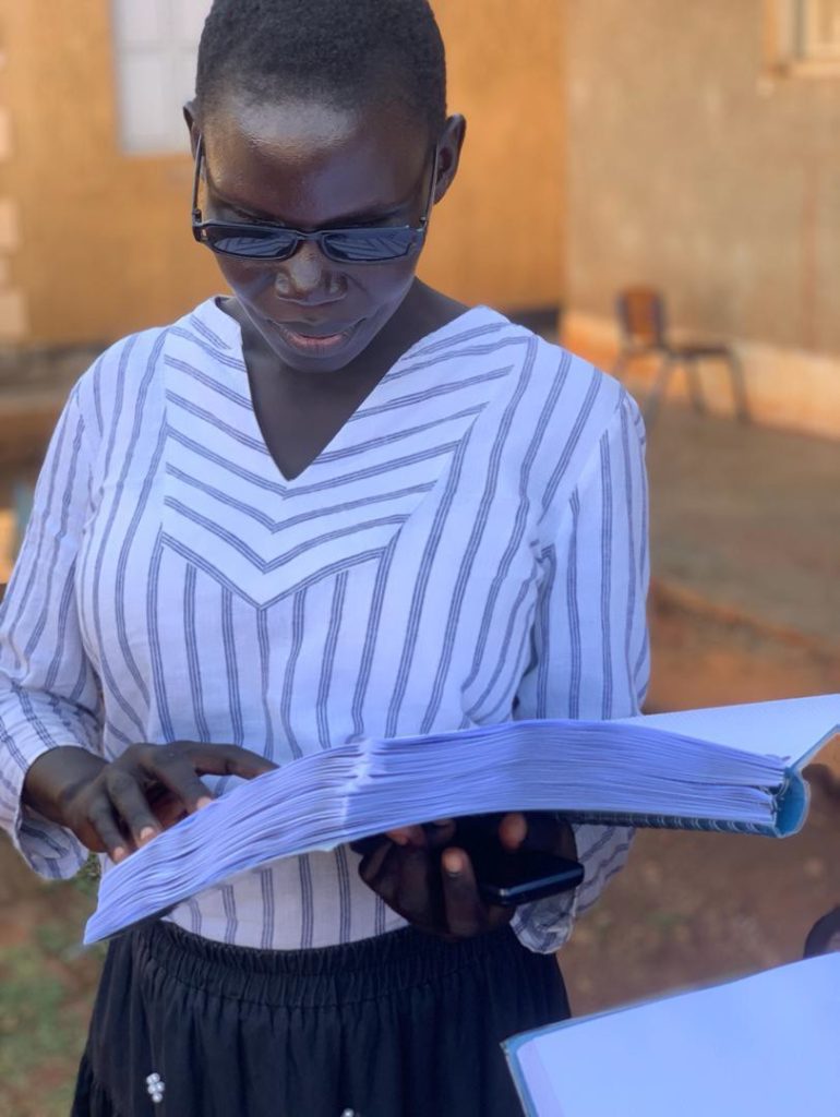 Young lady reading a braille Bible volume