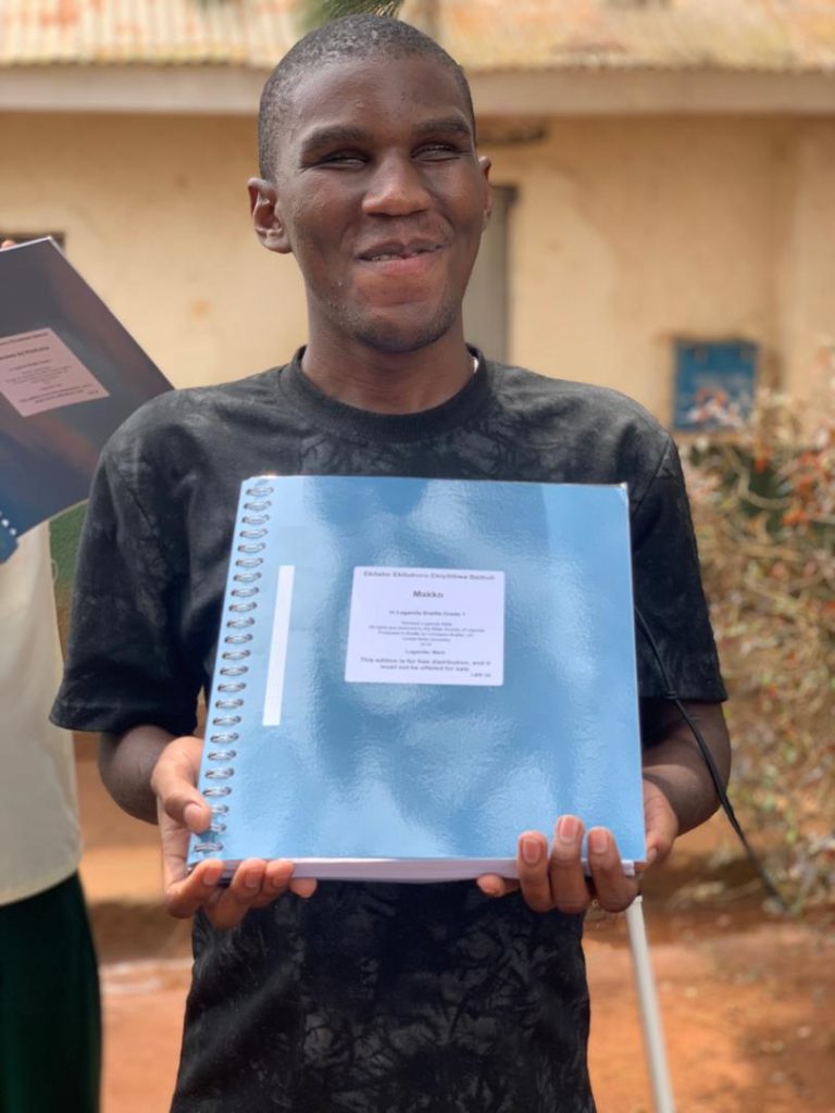 Young man holding braille Bible volume