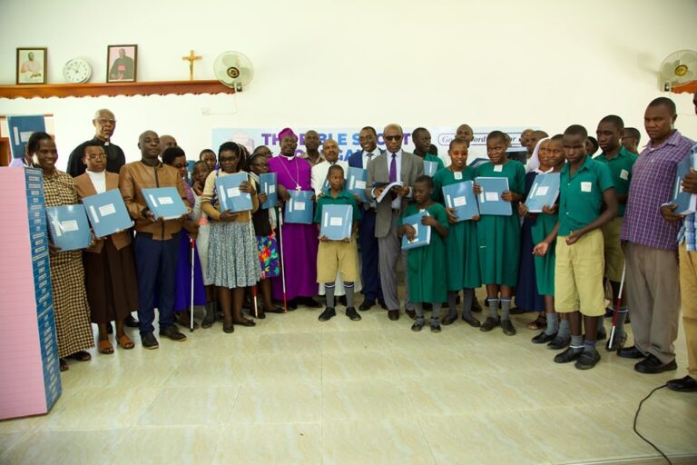 Group holding braille Runyankore/Rukiga Bible volumes