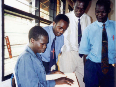 Boy demonstrating reading braille Bible volume