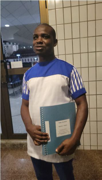 Man holding Asante Twi braille Bible volume