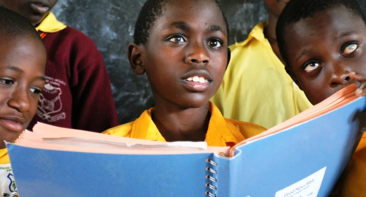 Ugandan boys holding braille Bible volume
