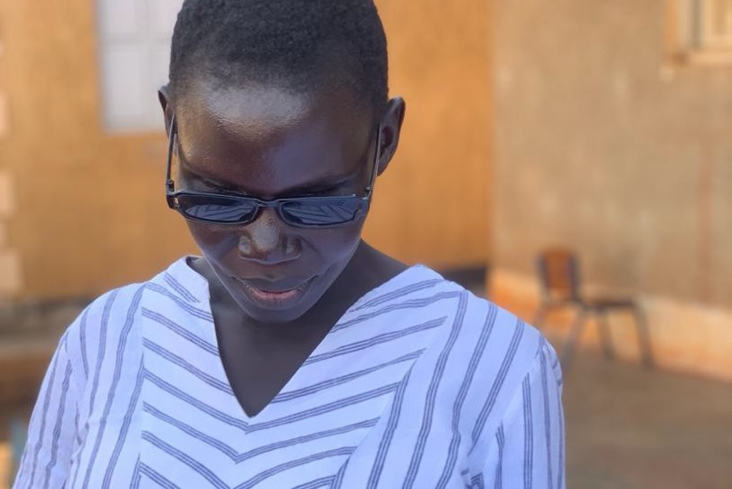 Young lady reading a braille Bible volume