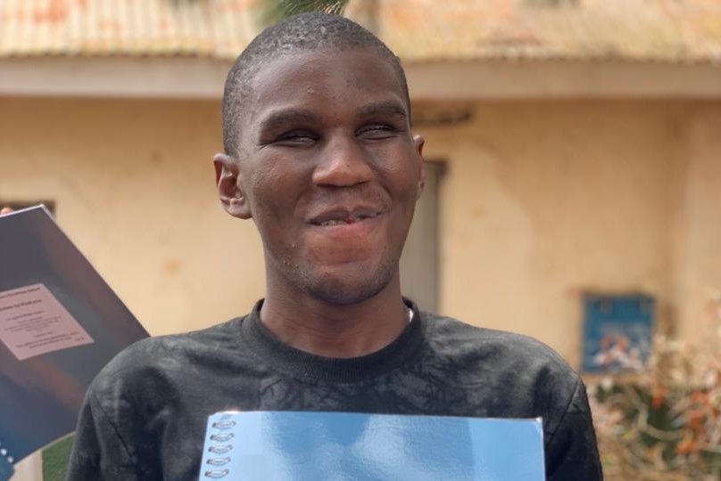 Young man holding braille bible volume