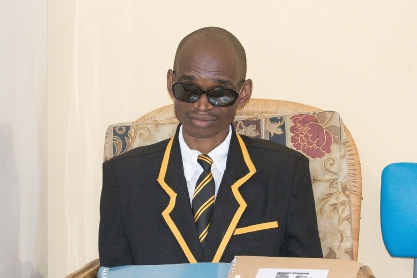 Young man holding braille volumes