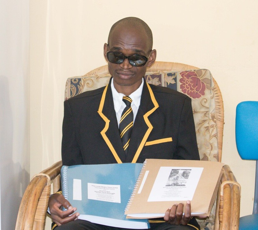 Young man holding braille volumes